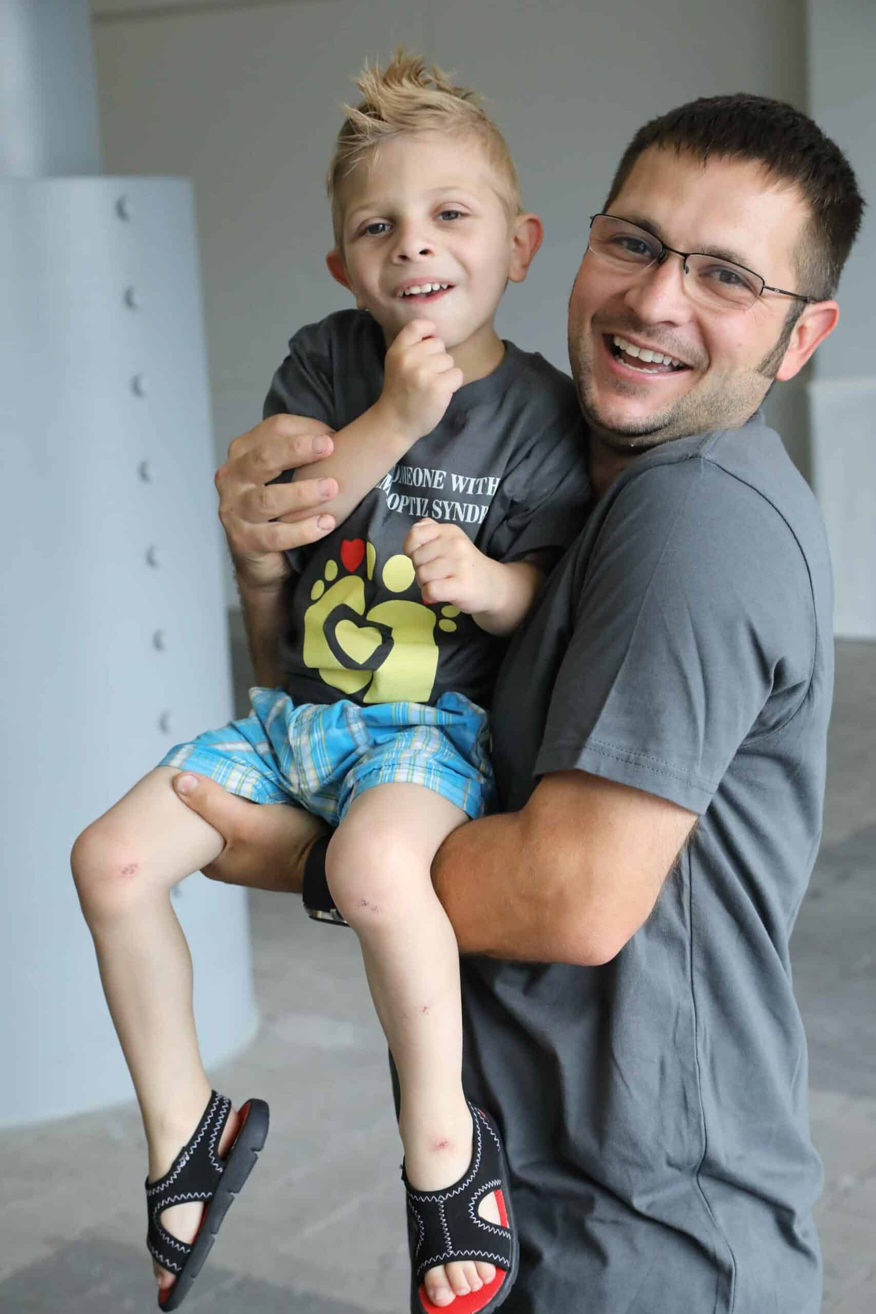 Father smiling and holding smiling son