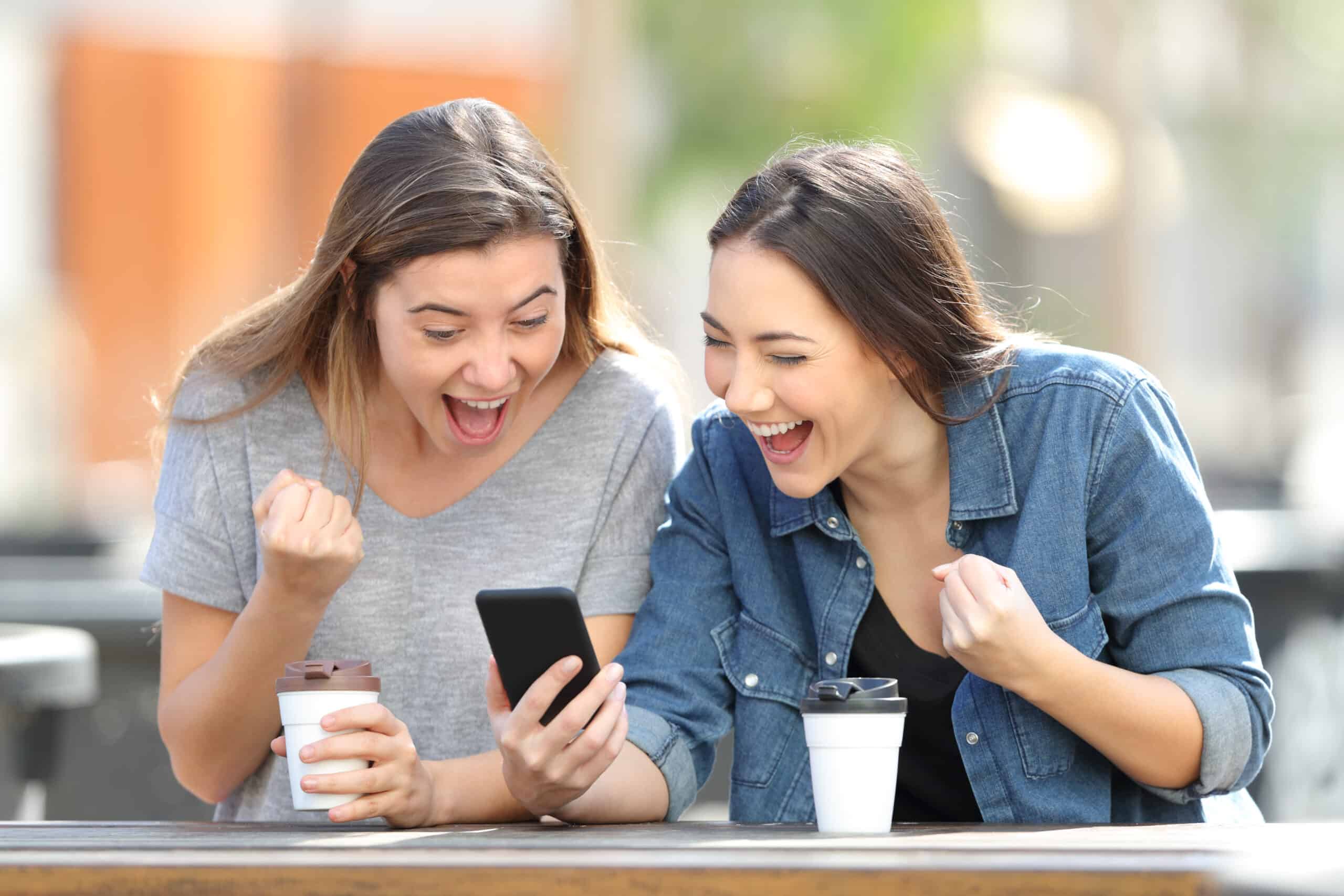 Friends happy as they look at their phones