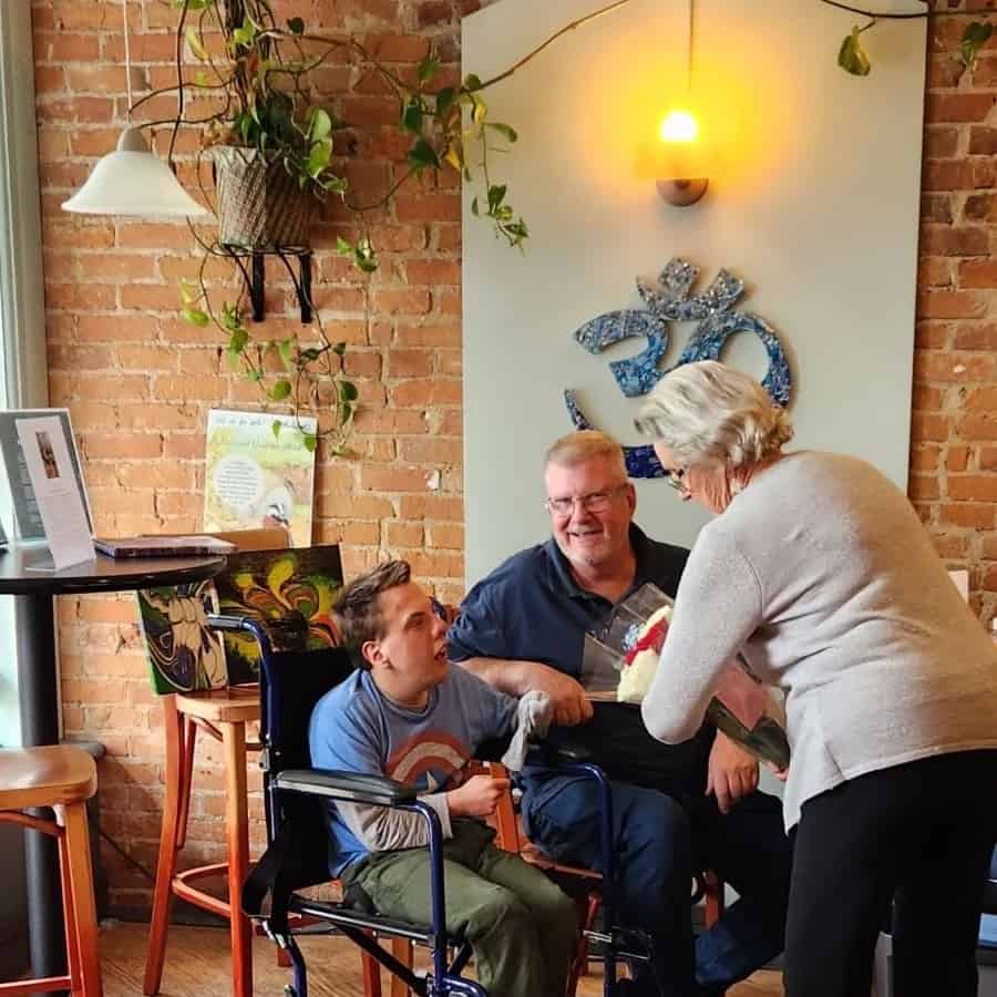 Carson G. speaking with a man and woman at the coffee shop during his art show